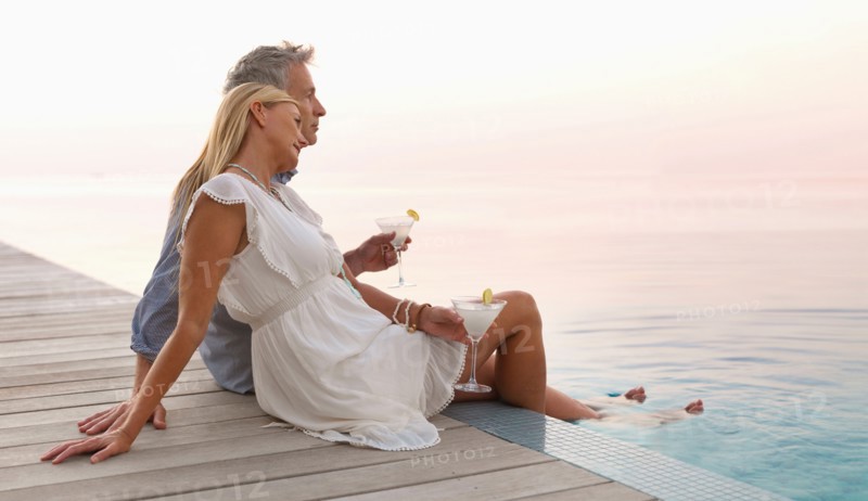 Mature couple sitting by seashore