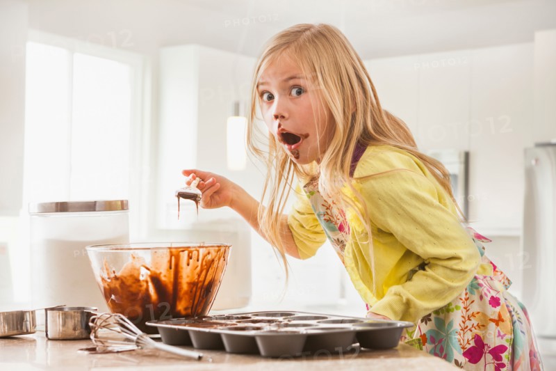 Girl (6-7) baking cupcakes