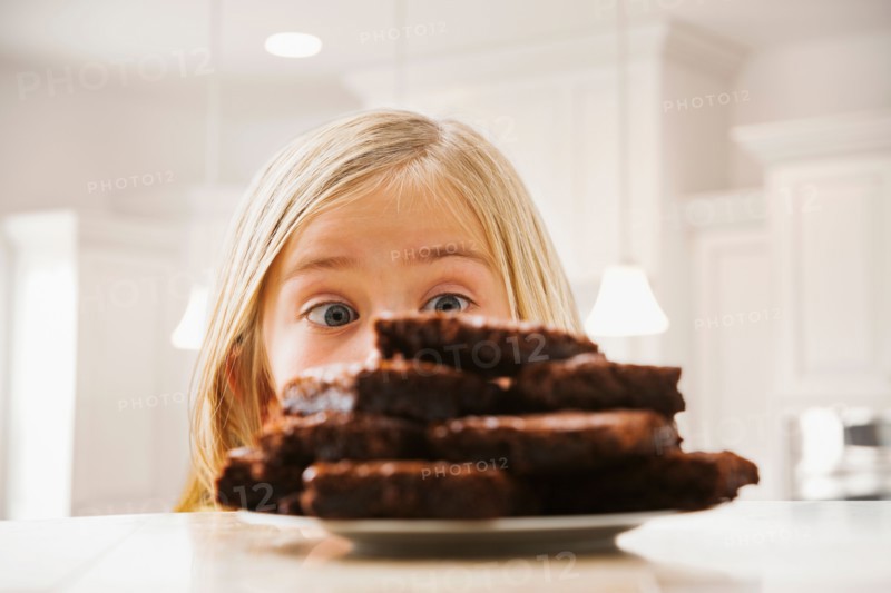 Girl (6-7) looking at heap of brownies
