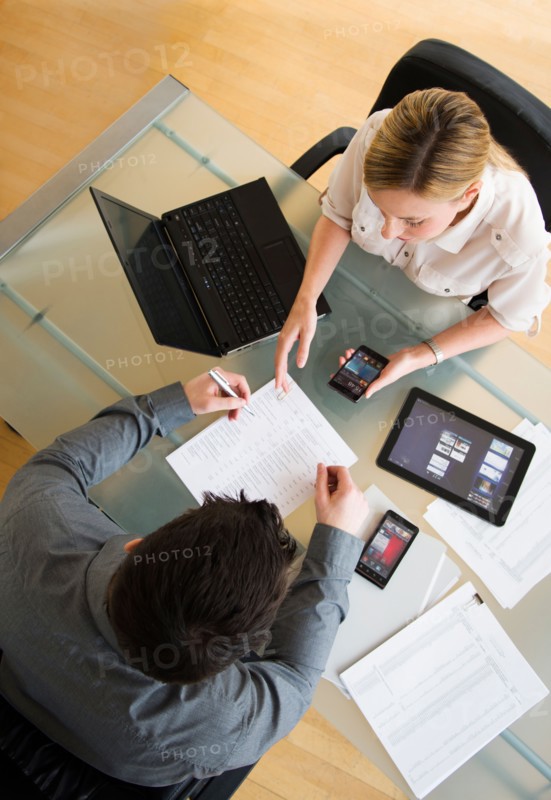 Business man and woman using mobile devices.