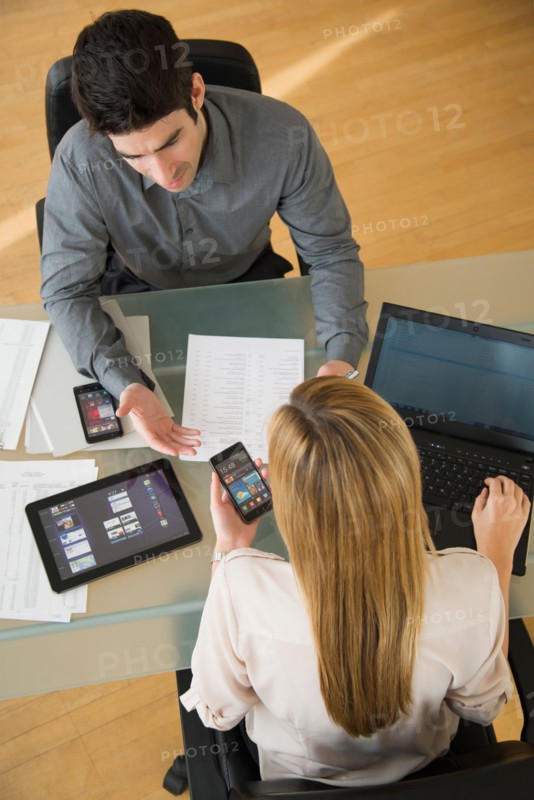 Business man and woman using mobile devices.