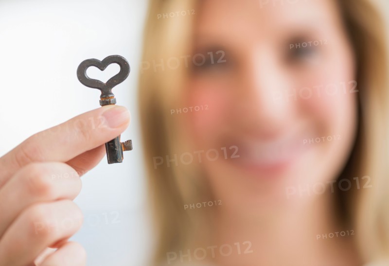 Woman holding heart-shaped key.