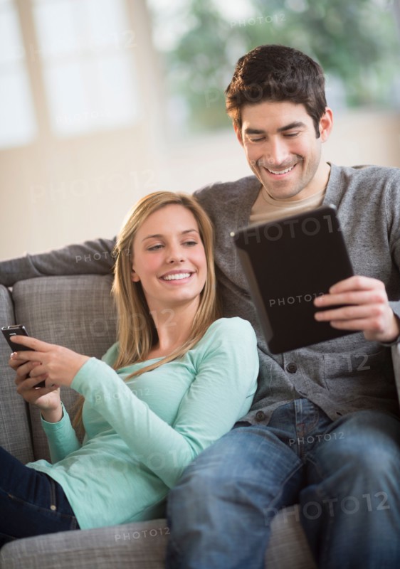 Couple using tablet pc and smartphone.