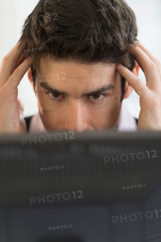Business man with head in hands.