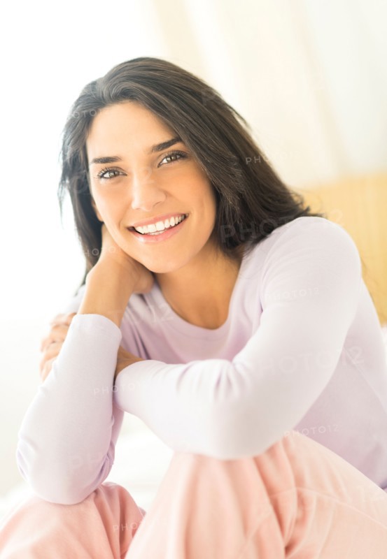 Woman sitting on bed.