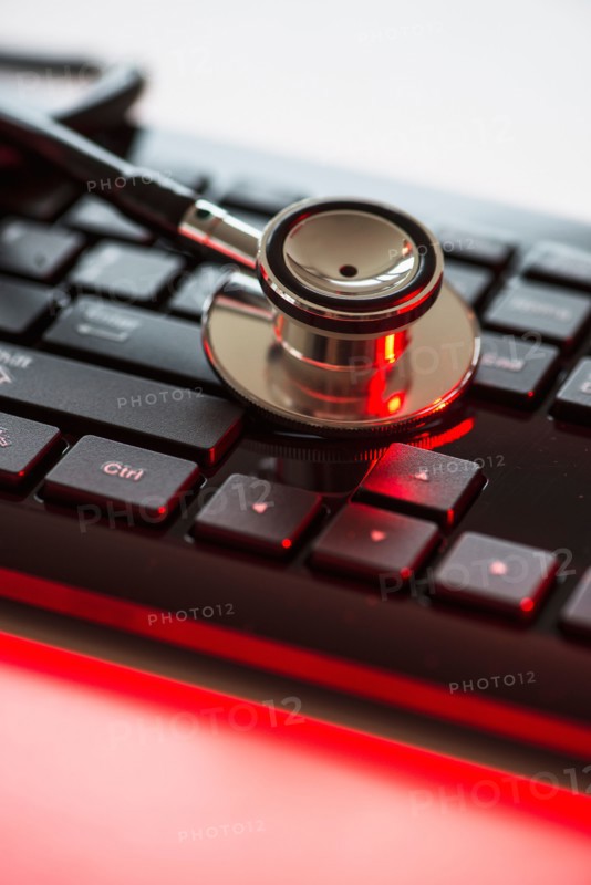 Close up of computer keyboard and stethoscope, studio shot.
