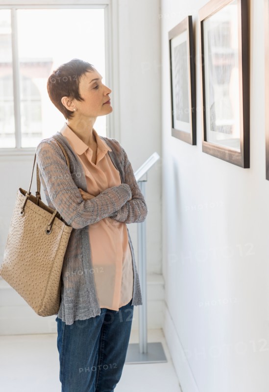 Woman watching photographs in art gallery.