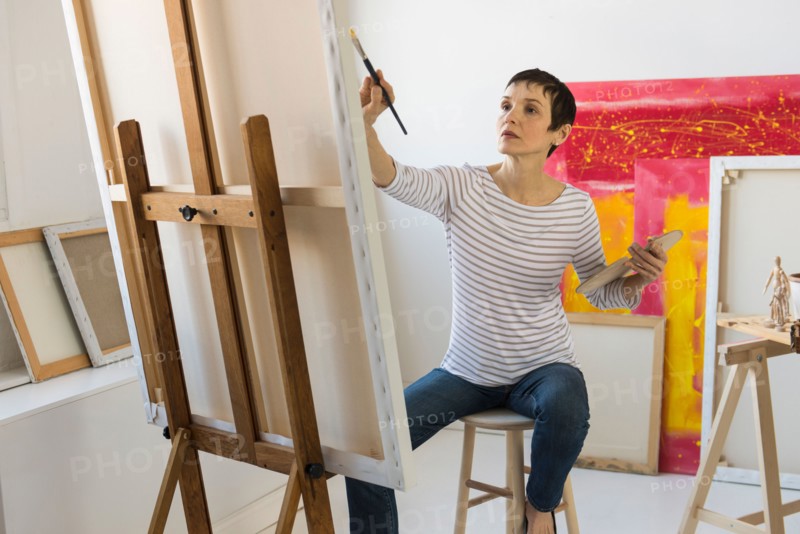 Female artist painting in her studio.