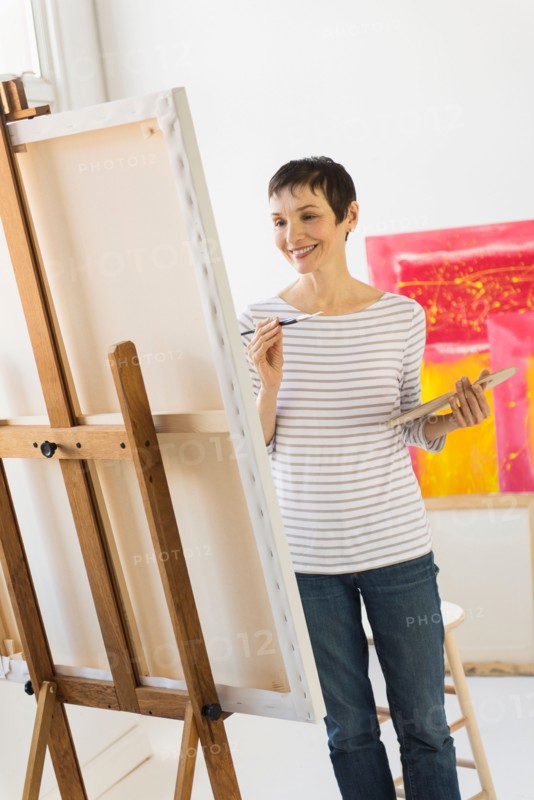 Female artist painting in her studio.
