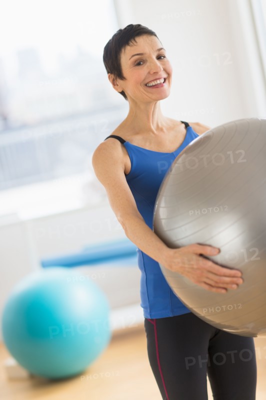 Portrait of mature woman exercising in gym.