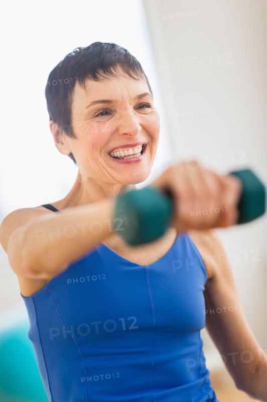 Mature woman exercising in gym.