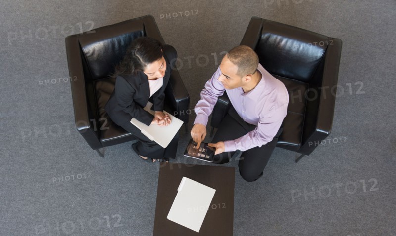Man and woman at meeting in office seen from above.