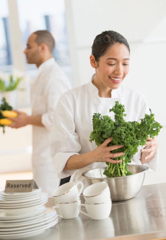 Couple during preparations in kitchen of their own restaurant.