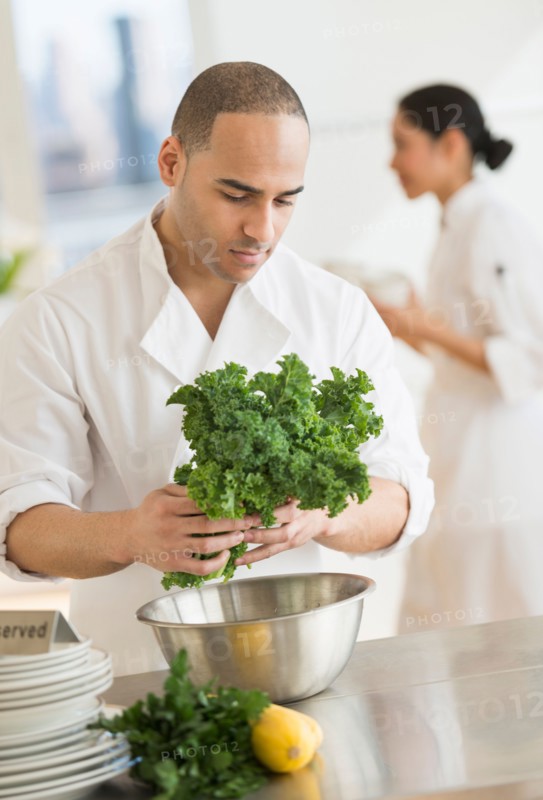 Couple during preparations in kitchen of their own restaurant.