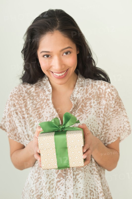 Young woman holding wrapped gift.