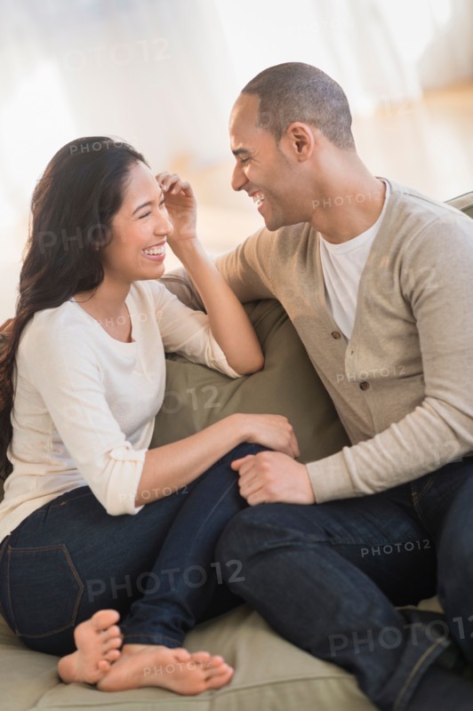 Portrait of young couple sitting on couch.