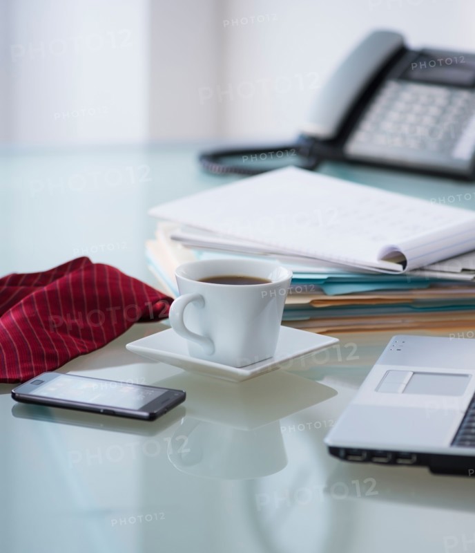 Close-up of coffee, paper material , tie, mobile phone and laptop