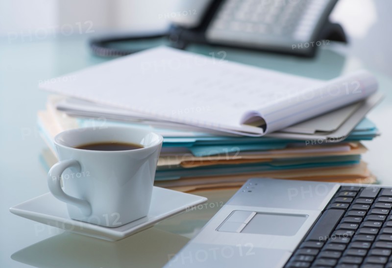 Close-up of coffee, paper material , laptop and telephone