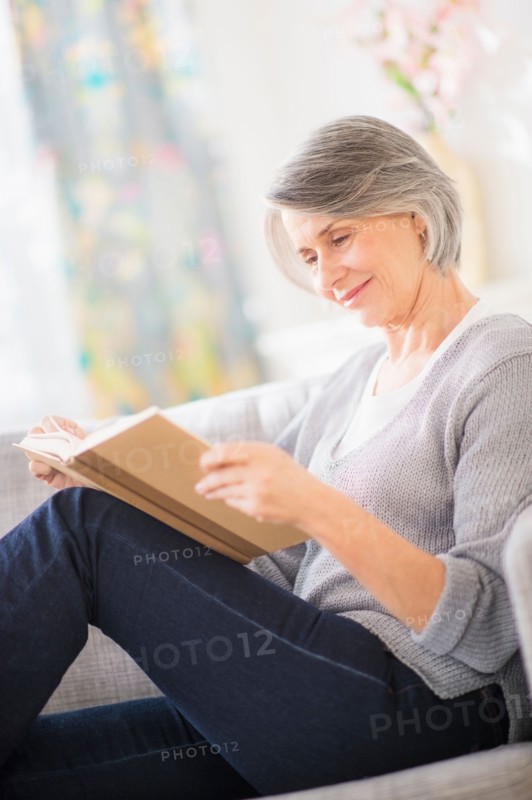Portrait of woman reading on sofa