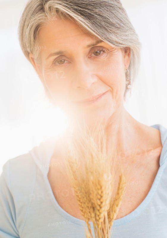 Portrait of pensive woman holding dry wheat