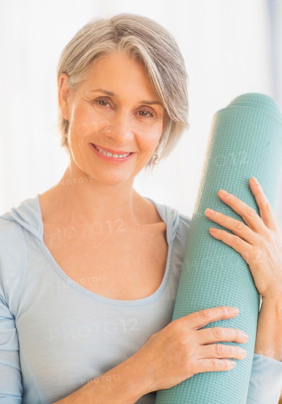 Portrait of woman holding yoga mat