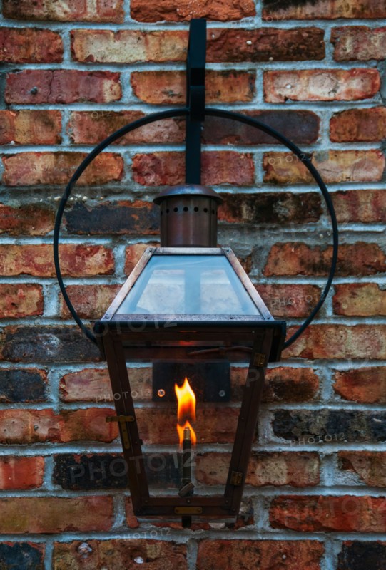 Close up of lantern hanging on brick wall