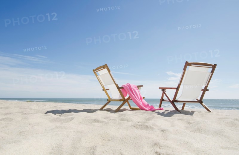 empty lounge chairs on sandy beach