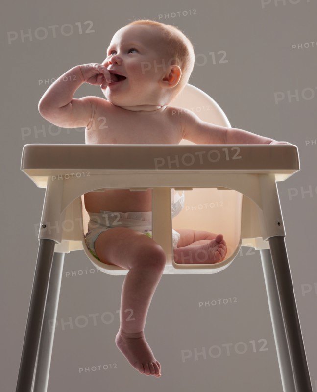 Studio shot of baby boy (18-23 months) sitting in baby seat