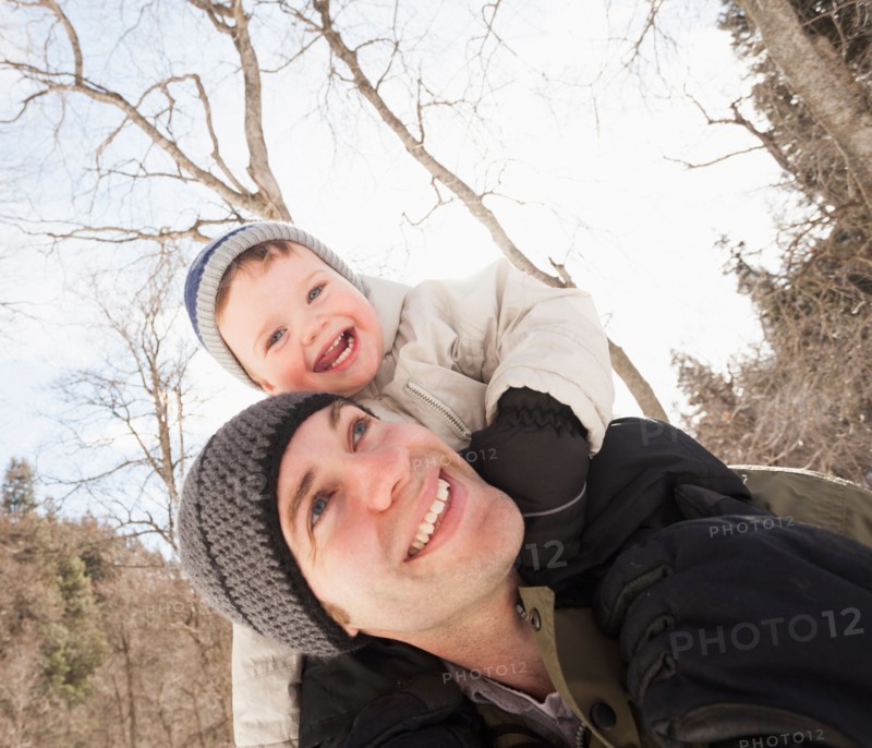 Young man carrying his son (12-17 months) on shoulders