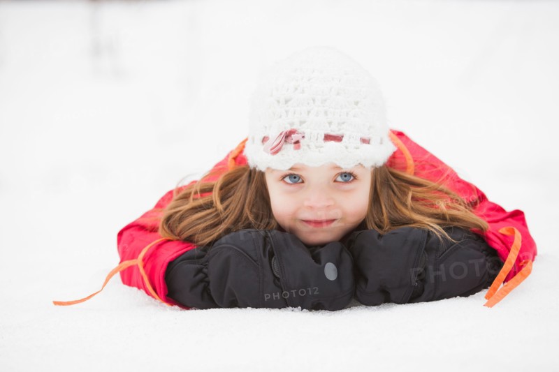 Portrait of girl (2-3) lying on snow