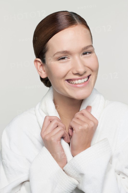 Studio shot portrait of young woman in bathrobe