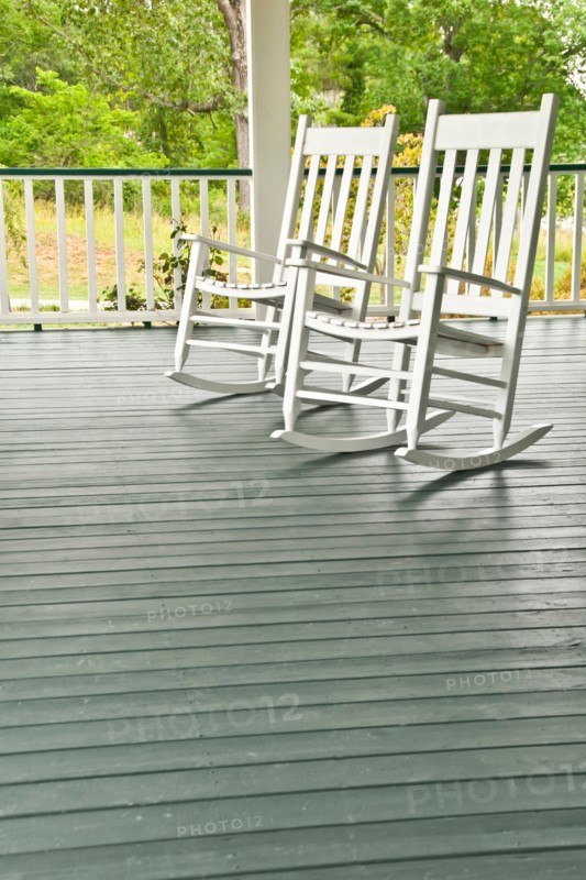 Two white rocking chairs on porch