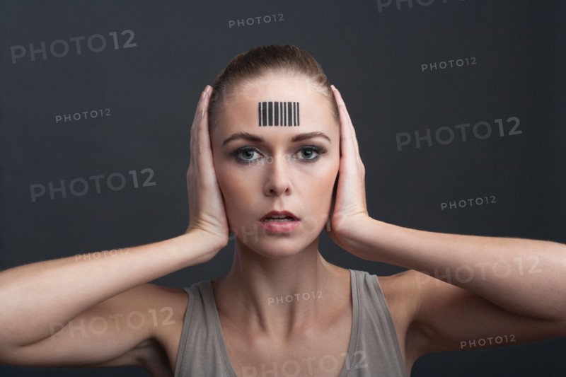 Studio portrait of woman with bar code on forehead