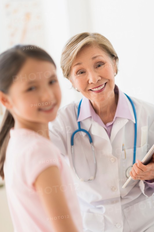 Portrait of doctor and girl (8-9) in foreground.