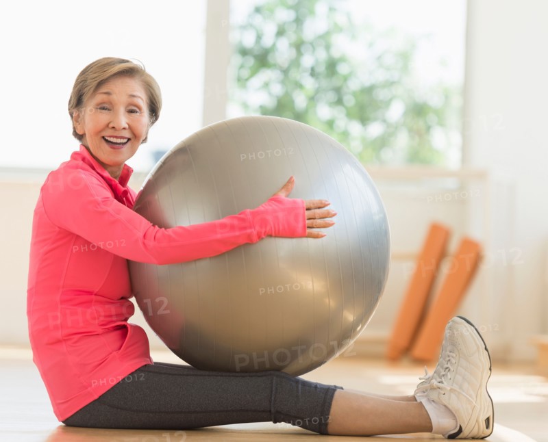 Senior woman exercising with fitness ball.
