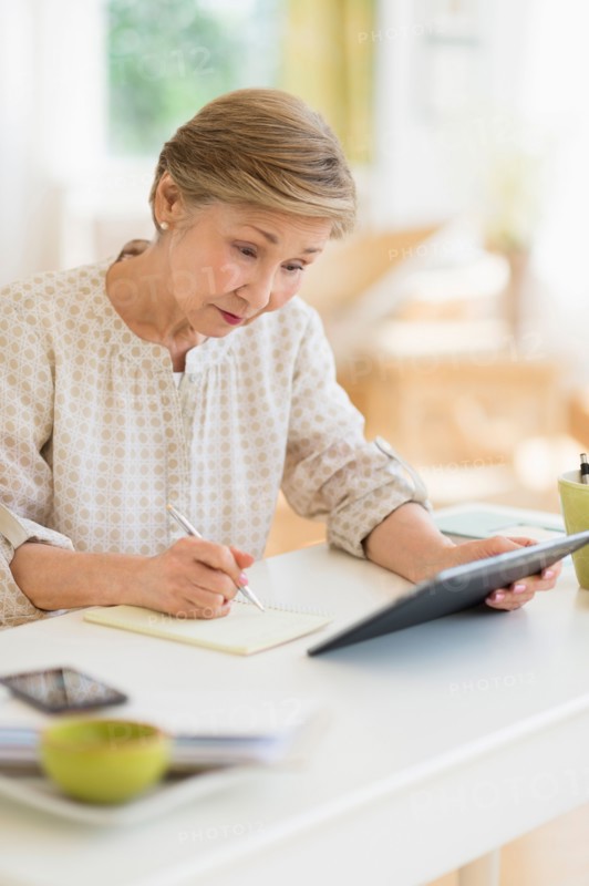 Senior woman using tablet pc at home.
