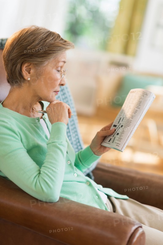 Senior woman doing crossword puzzle.