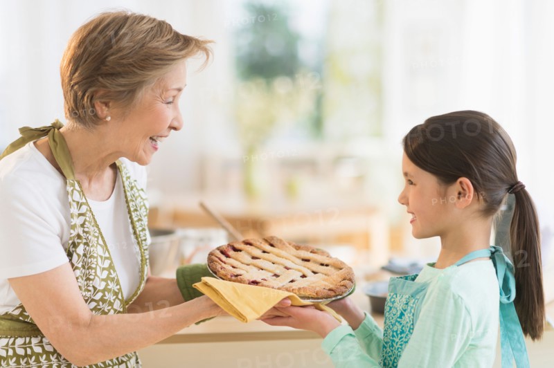 Grandmother and granddaughter (8-9) holding freshly baked pie.