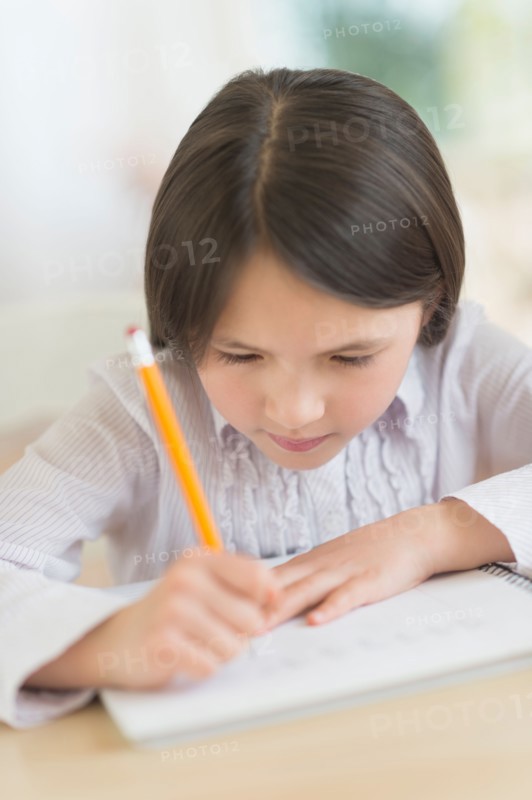 Girl (8-9) doing homework.