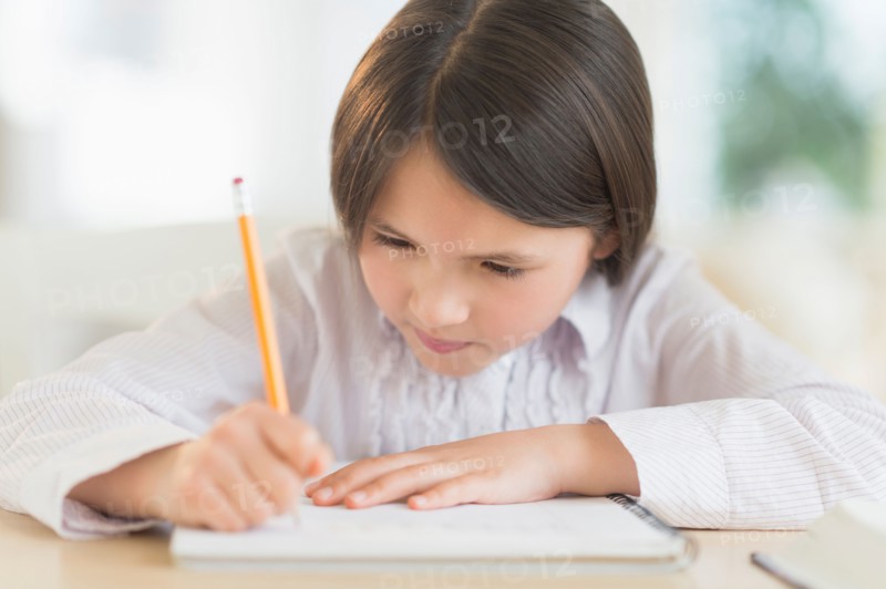 Girl (8-9) doing homework.