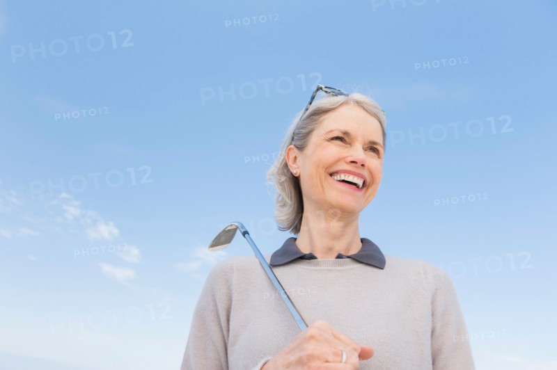Senior woman holding golf club.