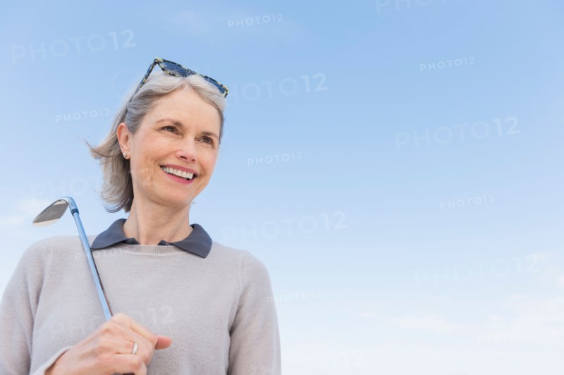 Senior woman holding golf club.
