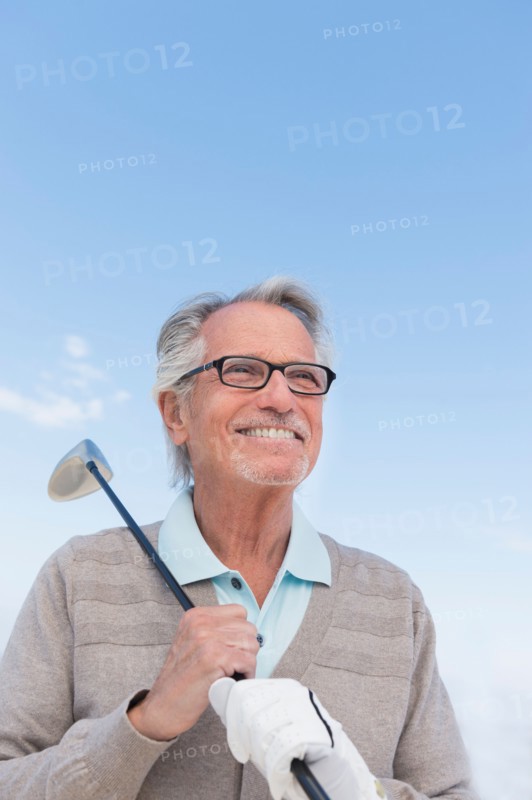 Senior man holding golf club.