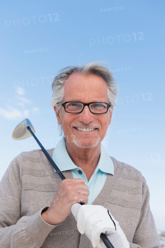 Senior man holding golf club.