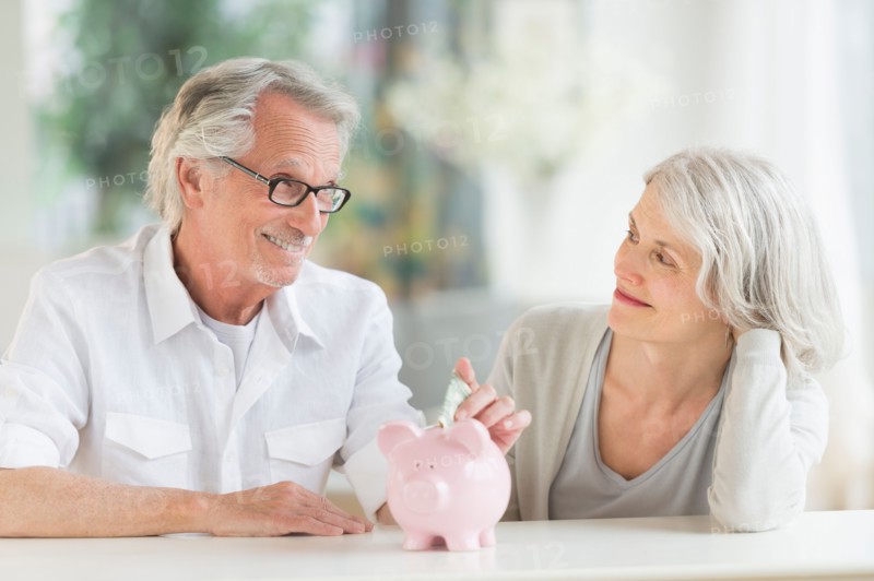 Senior couple with piggybank.