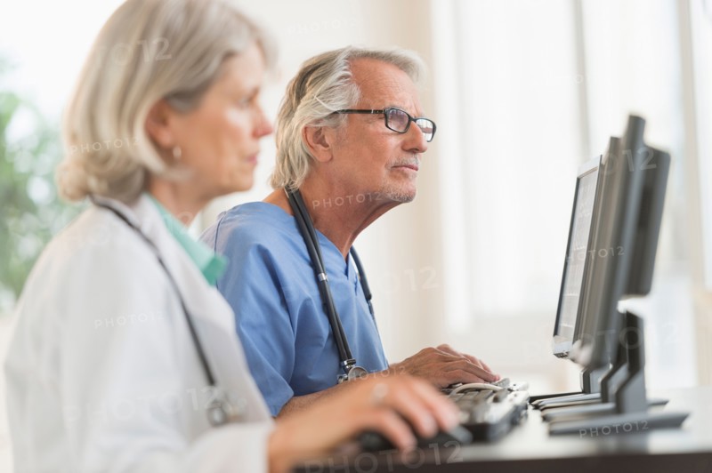 Female and male doctors working at computers.