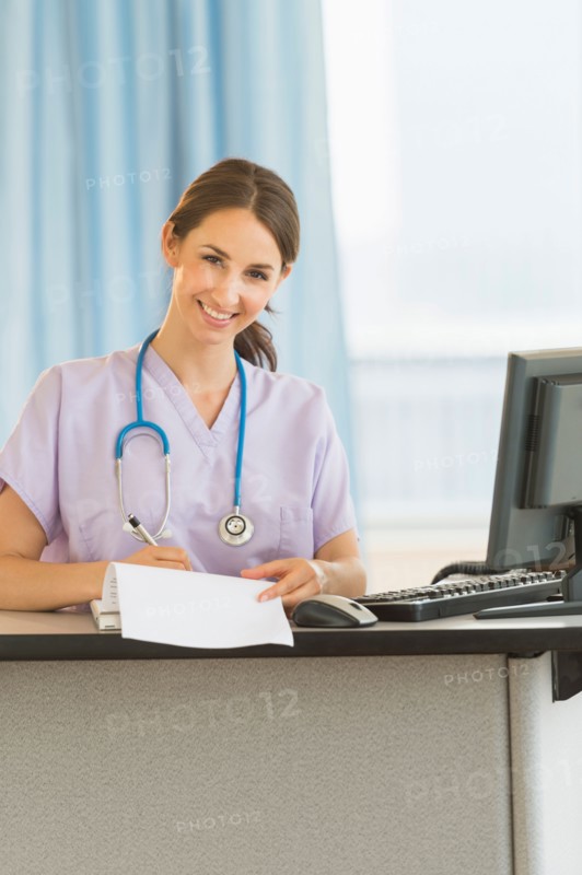 Portrait of female nurse at nurse's station in hospital.
