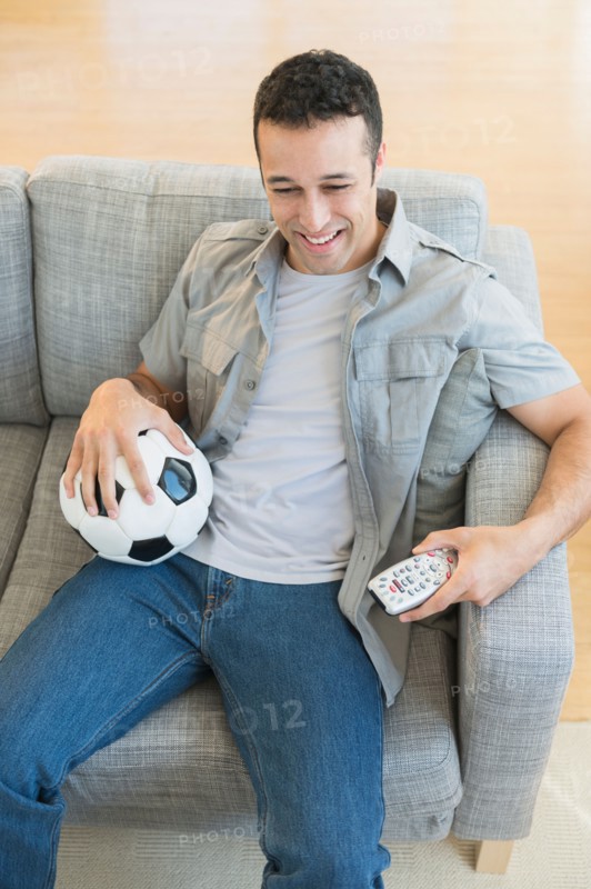 Young man watching soccer match on tv.