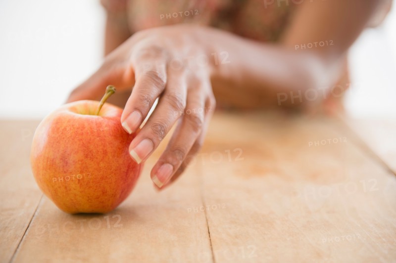 Woman's hand reaching for apple