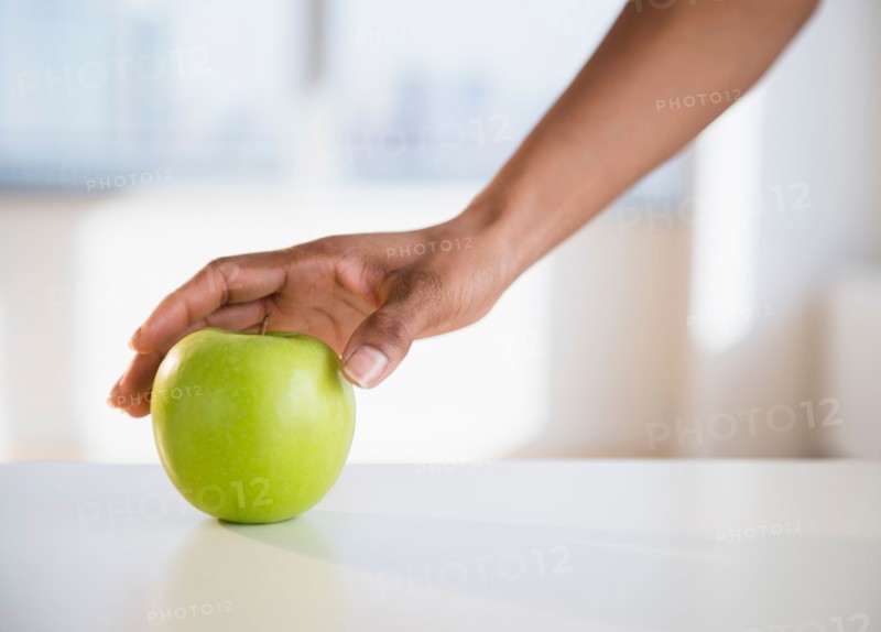Woman's hand reaching for apple